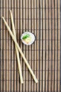 Sushi roll and wooden chopsticks lie on a bamboo straw serwing mat. Traditional Asian food. Top view. Flat lay minimalism shot