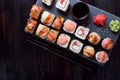 Sushi rolls assortment, wasabi, marinated ginger, soy sauce served on slate plate Royalty Free Stock Photo