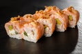 Sushi Rolls with avocado, shrimp, green onion, flamed salmon and Cream Cheese inside and fried onion on top on black slate