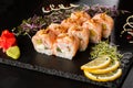 Sushi Rolls with avocado, shrimp, green onion, flamed salmon and Cream Cheese inside and fried onion on top on black slate