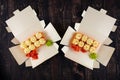 sushi rolls with cheese in an open paper container on a wooden table Royalty Free Stock Photo