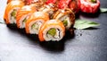 Sushi rolls closeup. Japanese food in restaurant. Roll with salmon, eel, vegetables and flying fish caviar Royalty Free Stock Photo