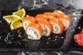 Sushi Rolls with cucumber, avocado, salmon and Cream Cheese inside on black slate isolated on black marble background. Royalty Free Stock Photo