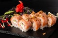 Sushi Rolls with cucumber, shrimp, crab meat, flamed salmon and Cream Cheese inside and fried onion on top on black