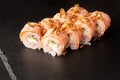 Sushi Rolls with cucumber, shrimp, crab meat, flamed salmon and Cream Cheese inside and fried onion on top on black