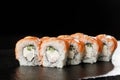 Sushi Rolls with cucumber, shrimp, salmon and Cream Cheese inside on black slate isolated. Philadelphia roll sushi with shrimp. Royalty Free Stock Photo