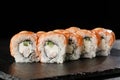 Sushi Rolls with cucumber, shrimp, salmon and Cream Cheese inside on black slate isolated. Philadelphia roll sushi with shrimp. Royalty Free Stock Photo