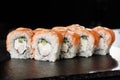 Sushi Rolls with cucumber, shrimp, salmon and Cream Cheese inside on black slate isolated. Philadelphia roll sushi with shrimp. Royalty Free Stock Photo