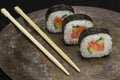 Sushi rolls on a dark metal plate, with chopsticks Royalty Free Stock Photo
