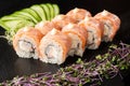 Sushi Rolls with flamed salmon, shrimp, crab meat and Cream Cheese inside on black slate isolated. Philadelphia roll sushi with Royalty Free Stock Photo