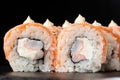Sushi Rolls with flamed salmon, shrimp, crab meat and Cream Cheese inside on black slate isolated. Philadelphia roll sushi with Royalty Free Stock Photo