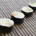 Sushi rolls lies on a bamboo straw serwing mat. Traditional Asian food