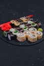 Sushi rolls and maki on a black plate, japanese food, black dark background, asian cuisine