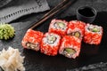 Sushi rolls and maki set with smoked eel, cream cheese, avocado, red caviar and wasabi on black slate background. Japanese cuisine Royalty Free Stock Photo