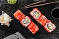 Sushi rolls and maki set with smoked eel, cream cheese, avocado, red caviar and wasabi on black slate background. Royalty Free Stock Photo