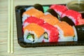 Sushi rolls pack in plastic container on a wooden table