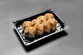 Sushi rolls in a package on a black background