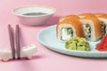 Sushi rolls Philadelphia with salmon and avocado. Roll ready to eat on blue plate with wasabi and soy sauce. Asian or Royalty Free Stock Photo