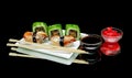 Sushi and rolls on a plate on a black background Royalty Free Stock Photo