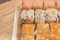Sushi rolls with salmon, black and white sesame, red caviar and sushi sticks
