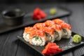 Sushi rolls with salmon, caviar, cucumber and cream cheese on a black plate on a dark background. Japanese food. Sushi Royalty Free Stock Photo