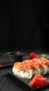 Sushi rolls with salmon, caviar, cucumber and cream cheese on a black plate on a dark background. Japanese food. Sushi Royalty Free Stock Photo