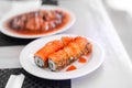 Sushi rolls set. Hand with chopsticks for sushi over white plate. Food at chinese buffet restaurant Royalty Free Stock Photo