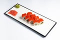 Sushi rolls set with red caviar and cream cheese served on a white plate over white background. Royalty Free Stock Photo