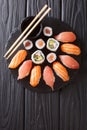 Sushi rolls set served on black stone slate on dark background. Royalty Free Stock Photo