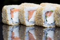 Sushi rolls shake chizu with sesame on a black background. Royalty Free Stock Photo