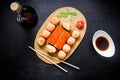 Sushi rolls, soy sauce and chopsticks on a black background. Japanese natural food. Top view. Flat lay. Royalty Free Stock Photo