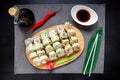 Sushi rolls, soy sauce, ginger and chopsticks on dark background. Top view. Flat lay. Royalty Free Stock Photo