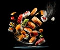 Sushi, rolls and soy sauce levitate over a plate on a black background Royalty Free Stock Photo