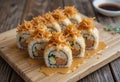 Sushi rolls with spicy mayo and crispy fried onions on top, rustic wooden table setup Royalty Free Stock Photo