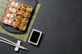 Sushi. Sushi rolls on a stone stick with chopsticks and sauce in a saucer. Sushi food photo for menu. Sushi baked with tuna and Royalty Free Stock Photo