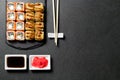 Sushi. Sushi rolls on a stone stick with chopsticks and sauce in a saucer. Sushi food photo for menu. Sushi baked with tuna and Royalty Free Stock Photo