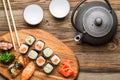 Sushi, rolls, teapot and cups on table Royalty Free Stock Photo