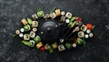 Sushi rolls and teapot with tea on black stone background. Royalty Free Stock Photo