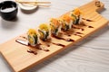 sushi rolls with tempura flakes and eel sauce on rectangular plate
