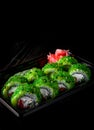 Sushi Rolls With Tobiko Green Caviar, cream cheese and fish on black wooden table