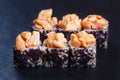 Sushi rolls topped with torched salmon and black caviar served