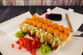 sushi rolls with wasabi cheese and ginger and salmon on a wooden table in an open paper container Royalty Free Stock Photo