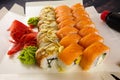 sushi rolls with wasabi cheese and ginger and salmon on a wooden table in an open paper container Royalty Free Stock Photo