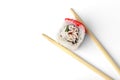 Sushi rolls with white fish, cucumber and tobiko caviar in chopsticks isolated on white background. Royalty Free Stock Photo