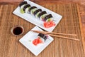 Top view of sushi on rectangular plates, condiments, chopsticks Royalty Free Stock Photo