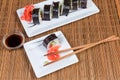 Top view of sushi on rectangular plates, condiments, chopsticks Royalty Free Stock Photo