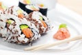 Sushi with salmon, avocado, rice in seaweed served with wasabi and ginger.