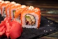 Sushi with salmon and rice with sesame seeds on a black background. Rolls, Japanese national cuisine, raw fish Royalty Free Stock Photo