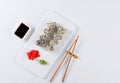 Sushi with salmon on a white plate with wasabi, ginger, soy, chopsticks on a white background Royalty Free Stock Photo