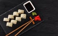 Sushi with salmon on a white plate with wasabi, ginger, soy, chopsticks on a black background Royalty Free Stock Photo